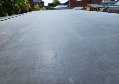 Wide EPDM flat roof surface showing lapped seams and the edge upstand