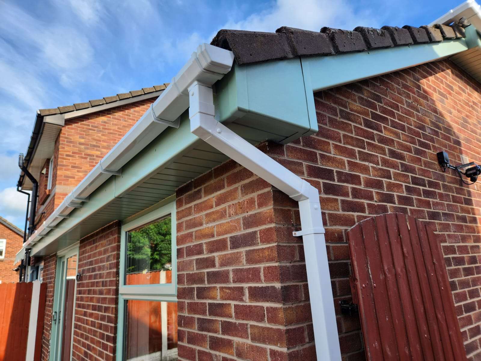New white UPVC guttering and downpipe fitted to a brick house by TRS